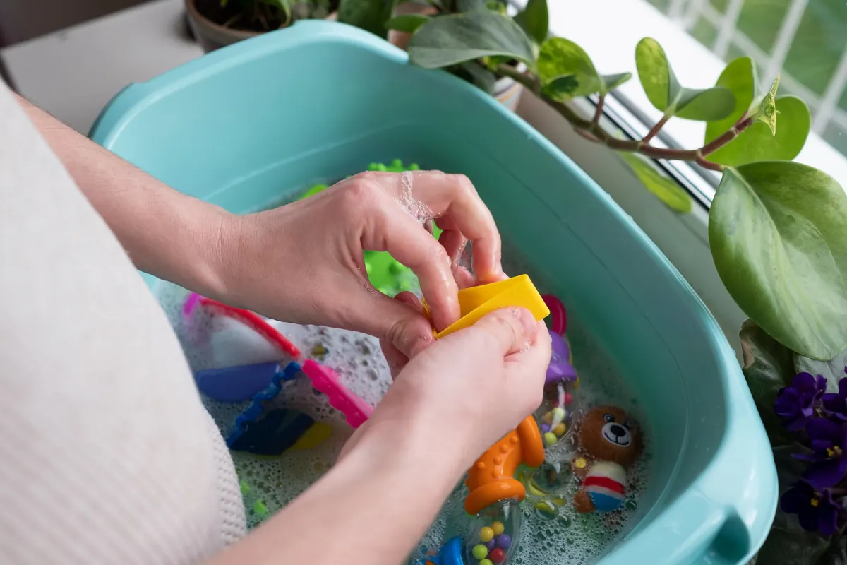 Buntes Kinderspielzeug wird in einer Schüssel mit Wasser gewaschen